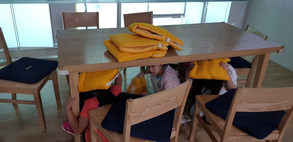 안전체험관 3층 지진체험관 지진발생시 가정에서 탁자아래로 대피하는 요령을 실습하고 있다.